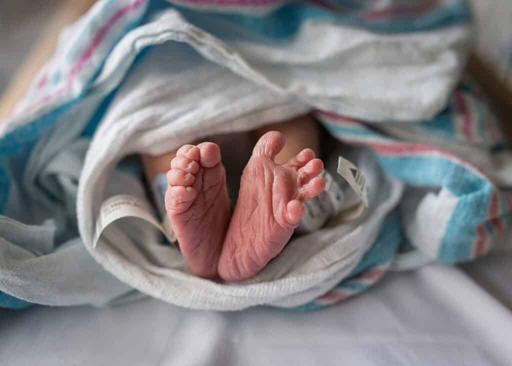 newborn baby feet in a hospital bassinet sleeping  tips to taking your own photos at the hospital 
