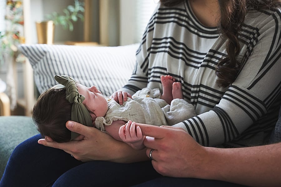what does an in home newborn session look like mom holding baby holding dads finger