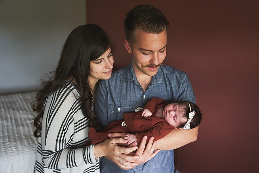 mom and dad holding baby with lots of dark hair newborn photography in pittsburgh