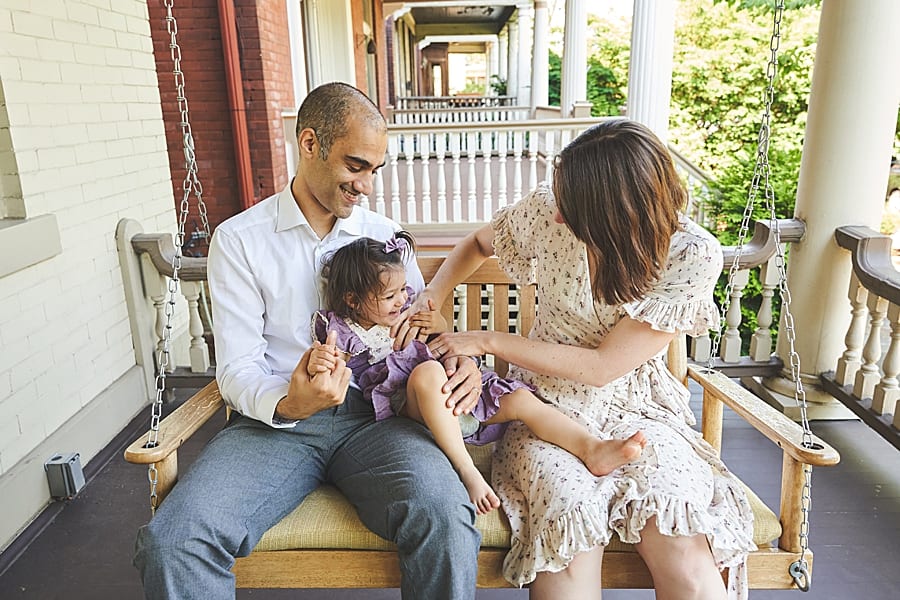 Family on porch swing of Shadyside home in pittsburgh for a family photo session 