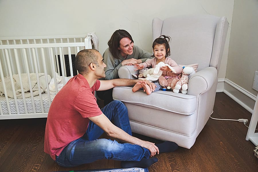 mom dad and toddler girl in nursery of Shadyside home for photo session 