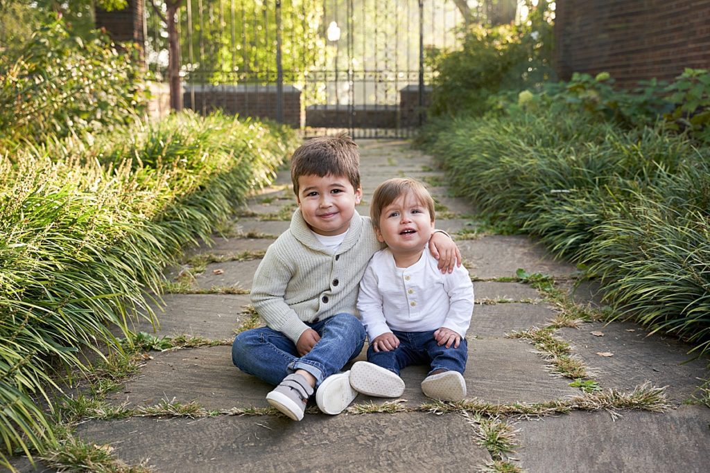 brothers sitting on path of the Mellon Park walled garden for a family photo session 