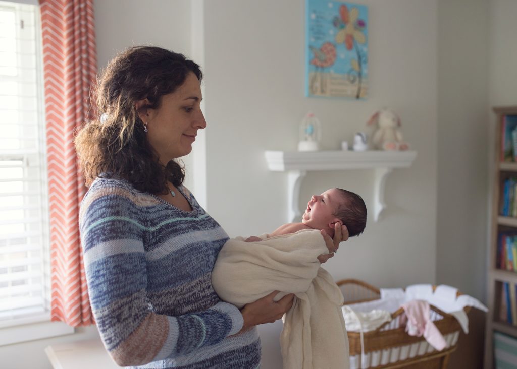 mom holding newborn baby in nursery of pittsburgh home