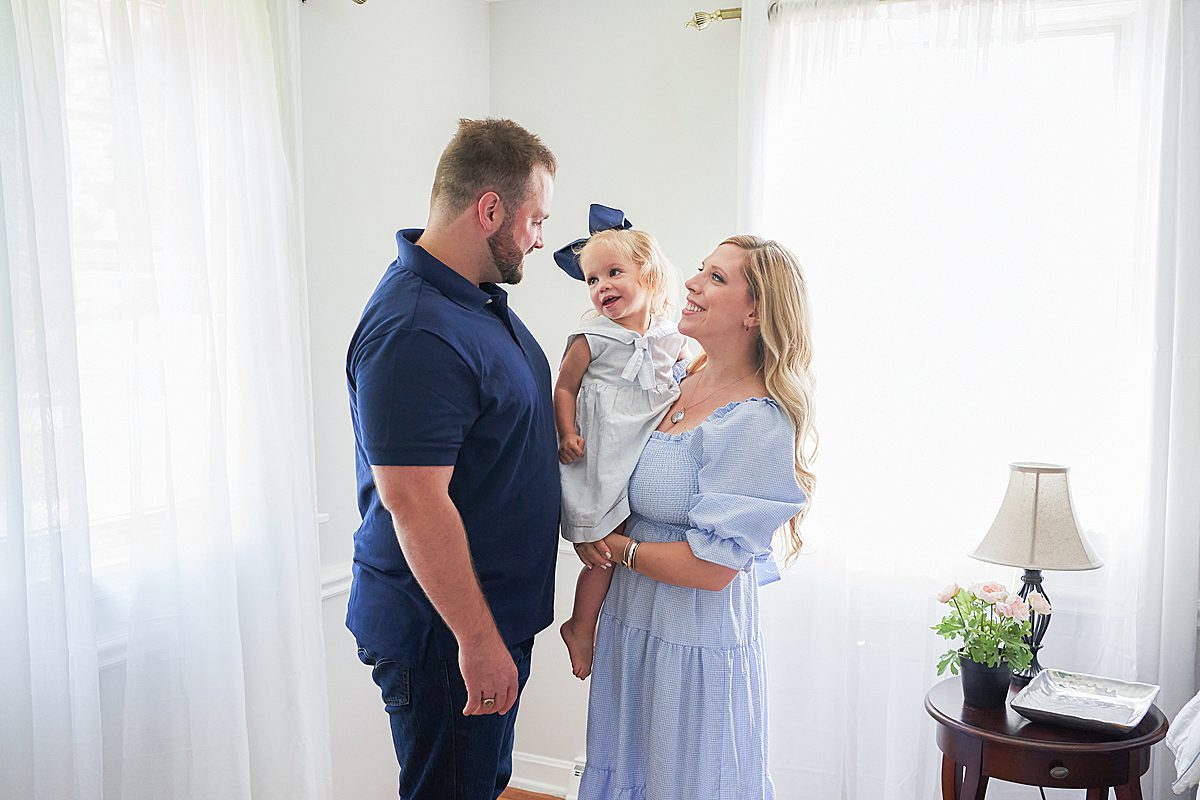 upper saint clair family photo session in home with mom and dad and child in the bedroom 