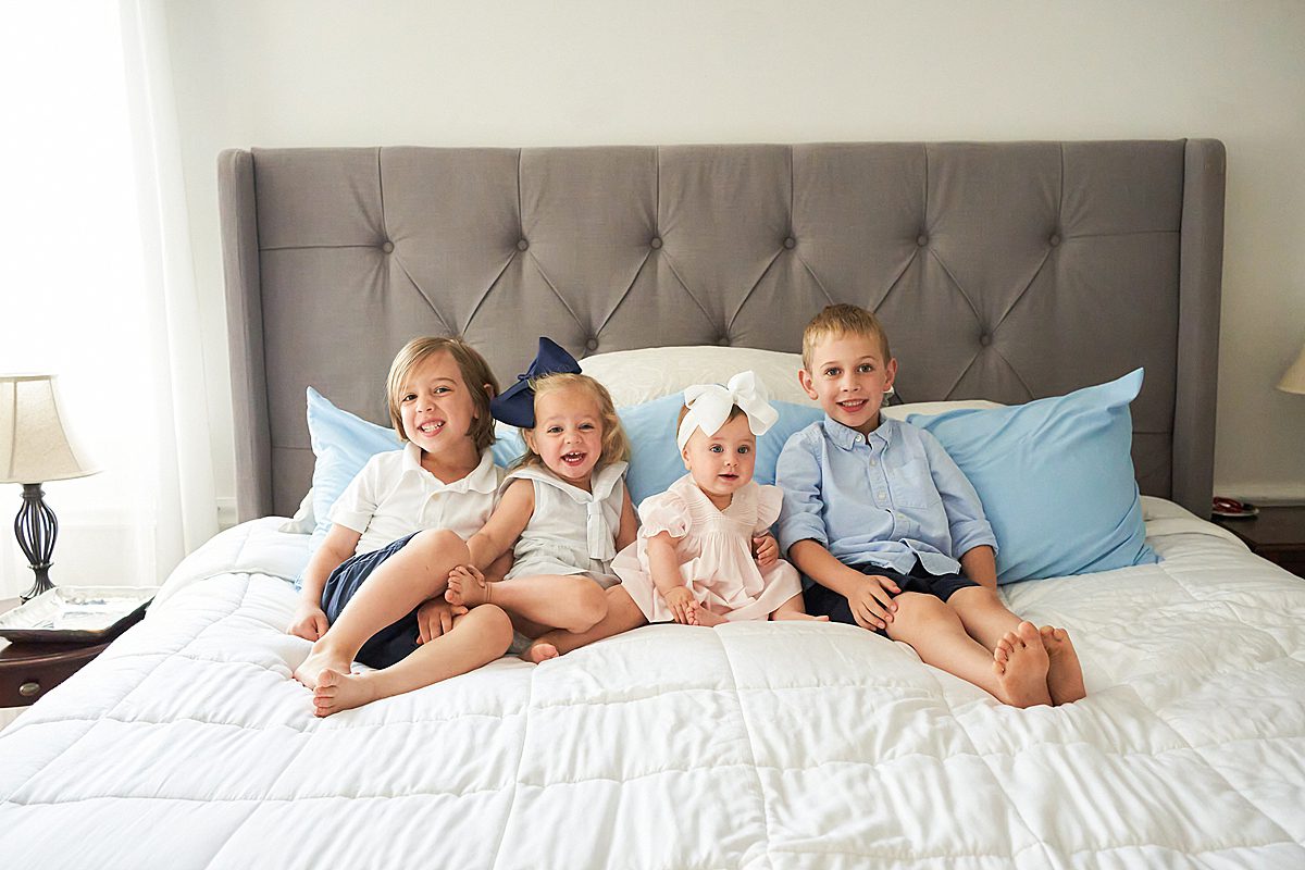 4 siblings sitting on the bed for family session in upper saint clair