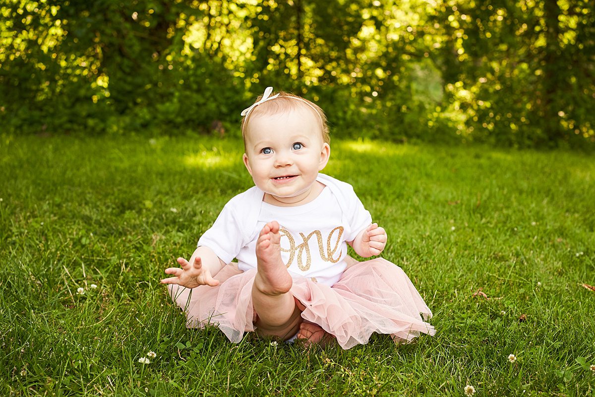baby girl in first birthday outfit in beechwood park in fox chapel for a family photo session 