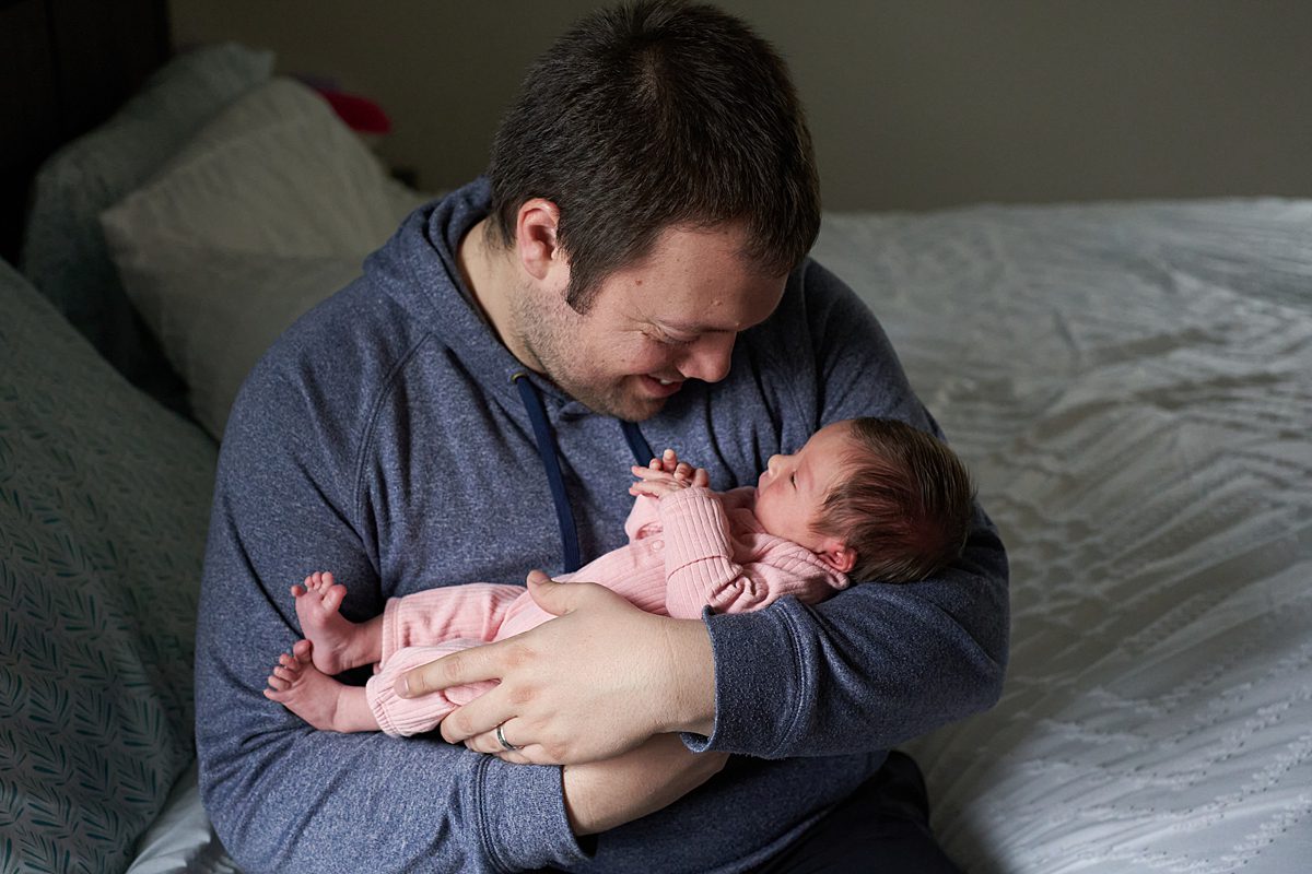 dad holding baby girl in pink seven fields newborn photographer 