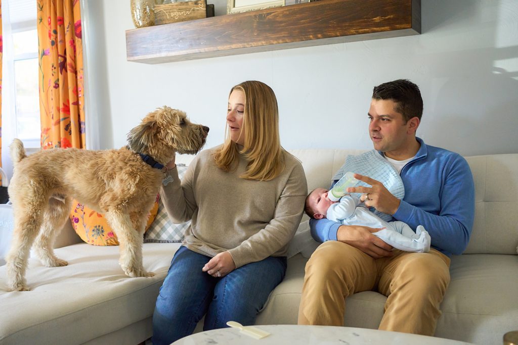 mom dad and baby with dog on couch at mccandless area home