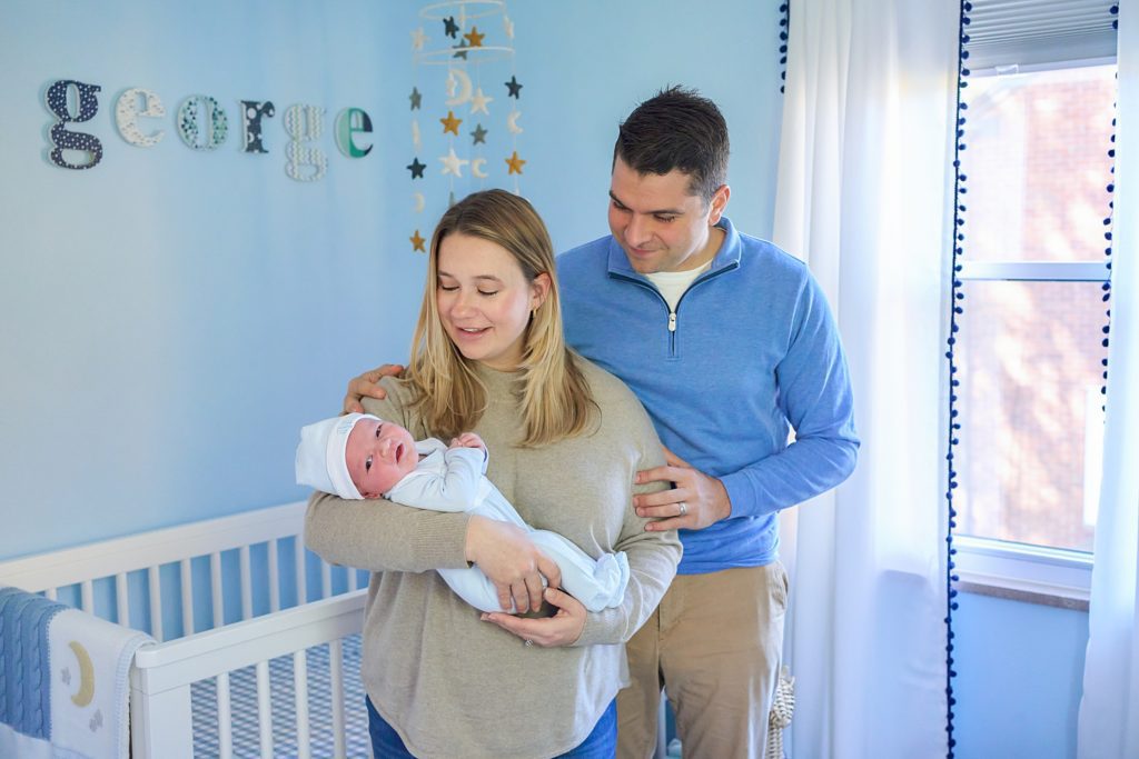 mom dad and newborn baby with dog in nursery at mccandless area home