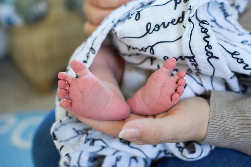 baby feet wrapped in muslin LOVE blanket