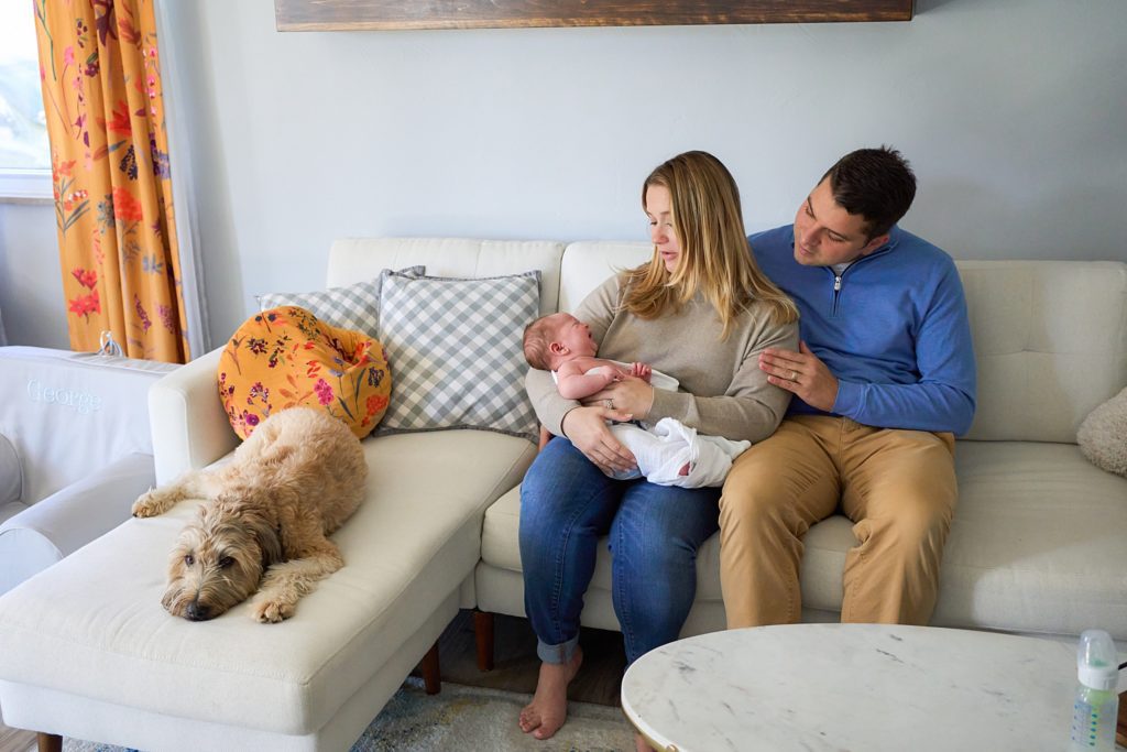 mom dad and baby with dog on couch at mccandless area home