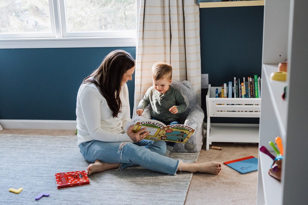 mom and son reading a book in nursery of wexford home for a family photo session 