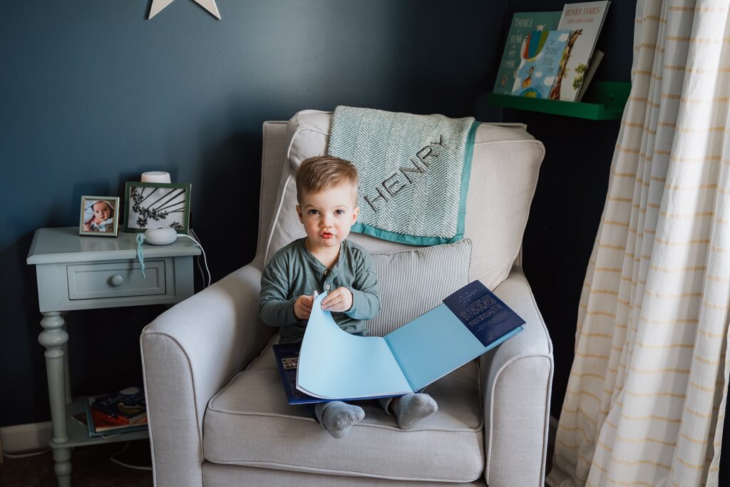 little boy reading a book in nursery of wexford home for a family photo session 