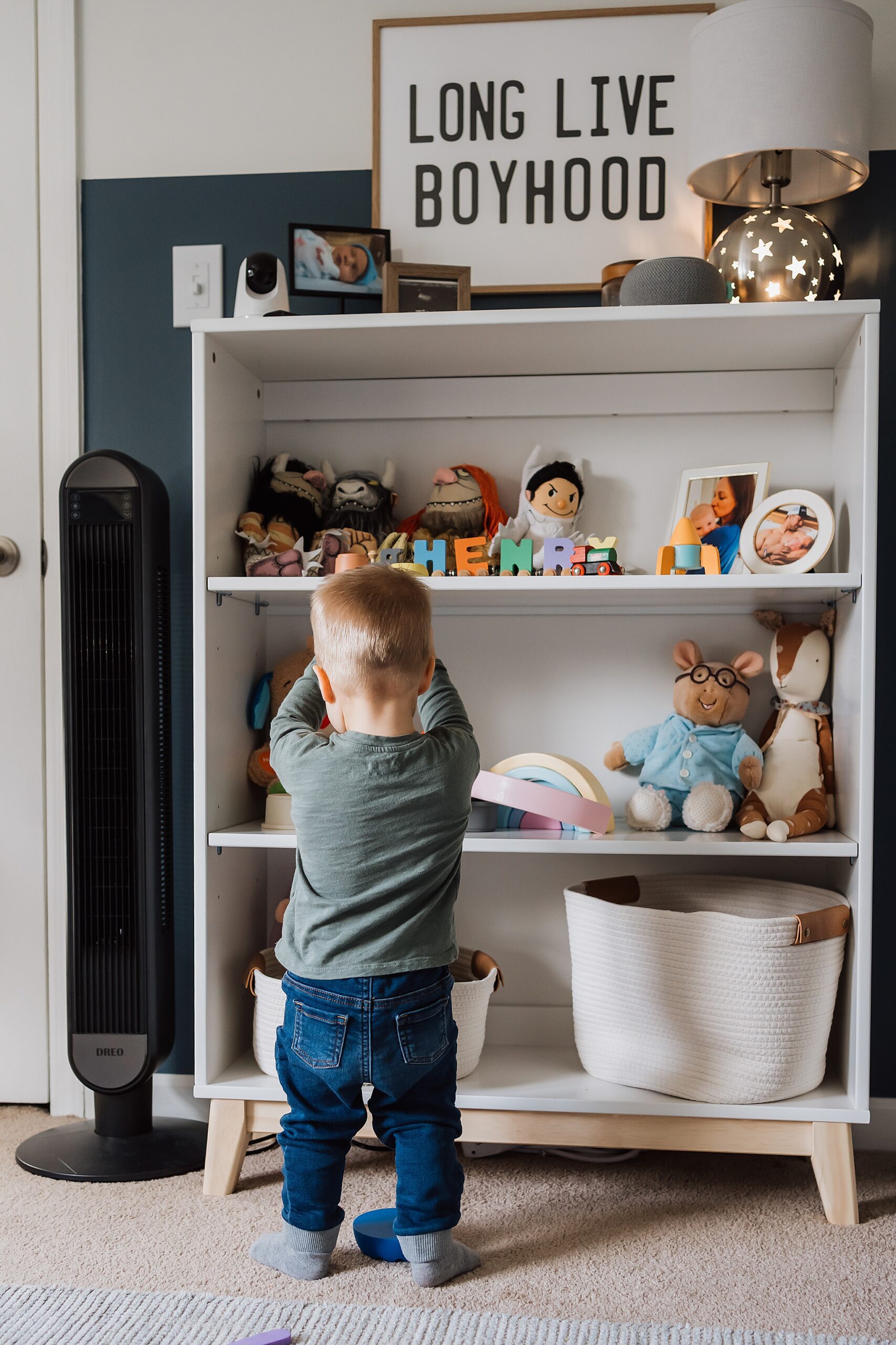 toddler in front of book shelf back to camera