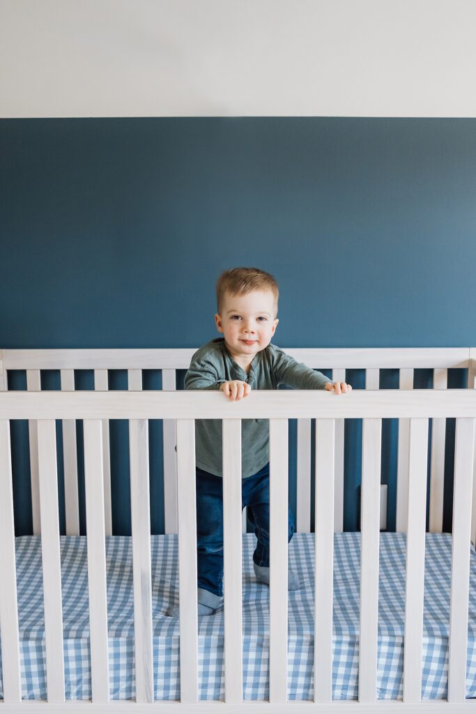 toddler in crib of nursery of wexford home for a family photo session 