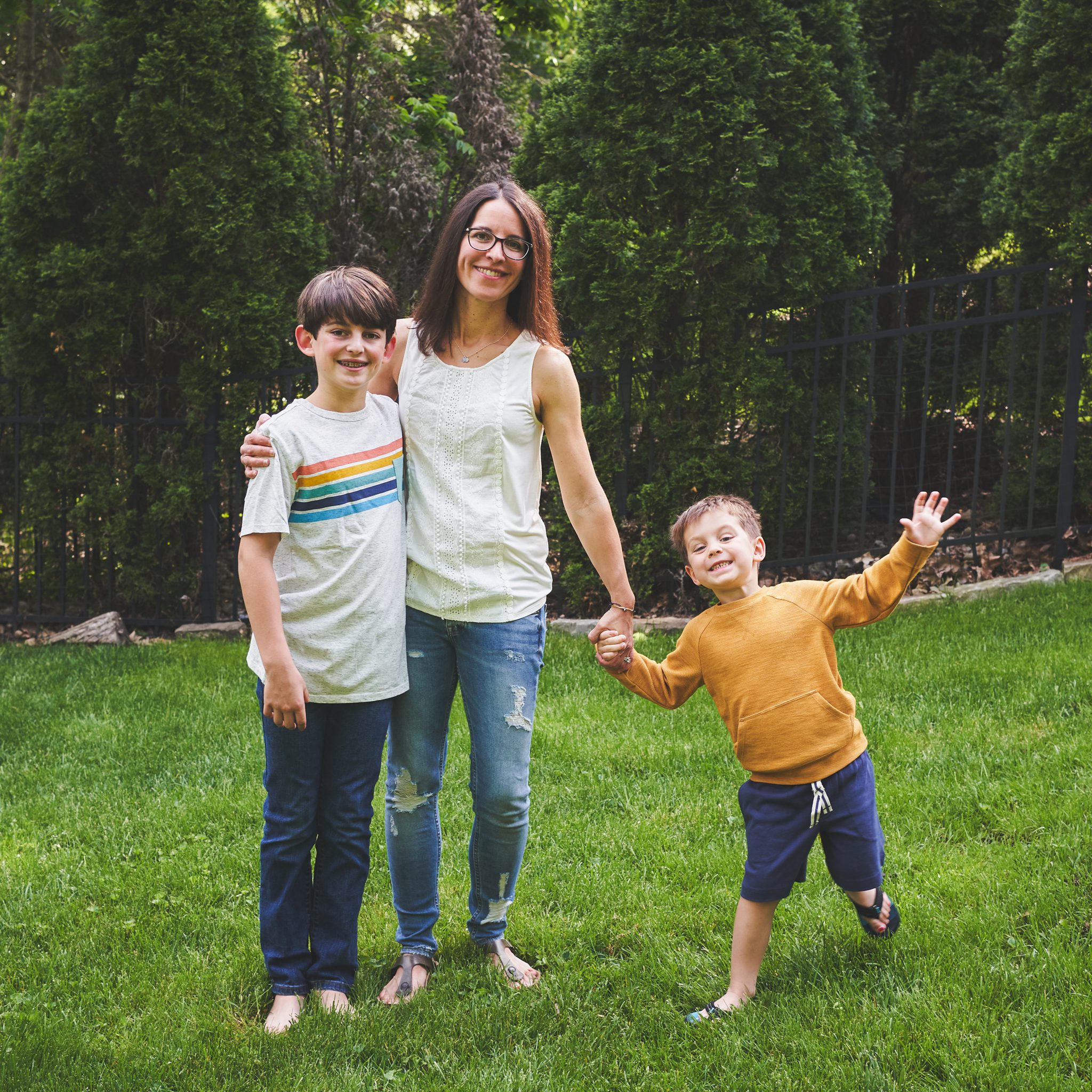 mother with 2 sons posing in back yard for a photo