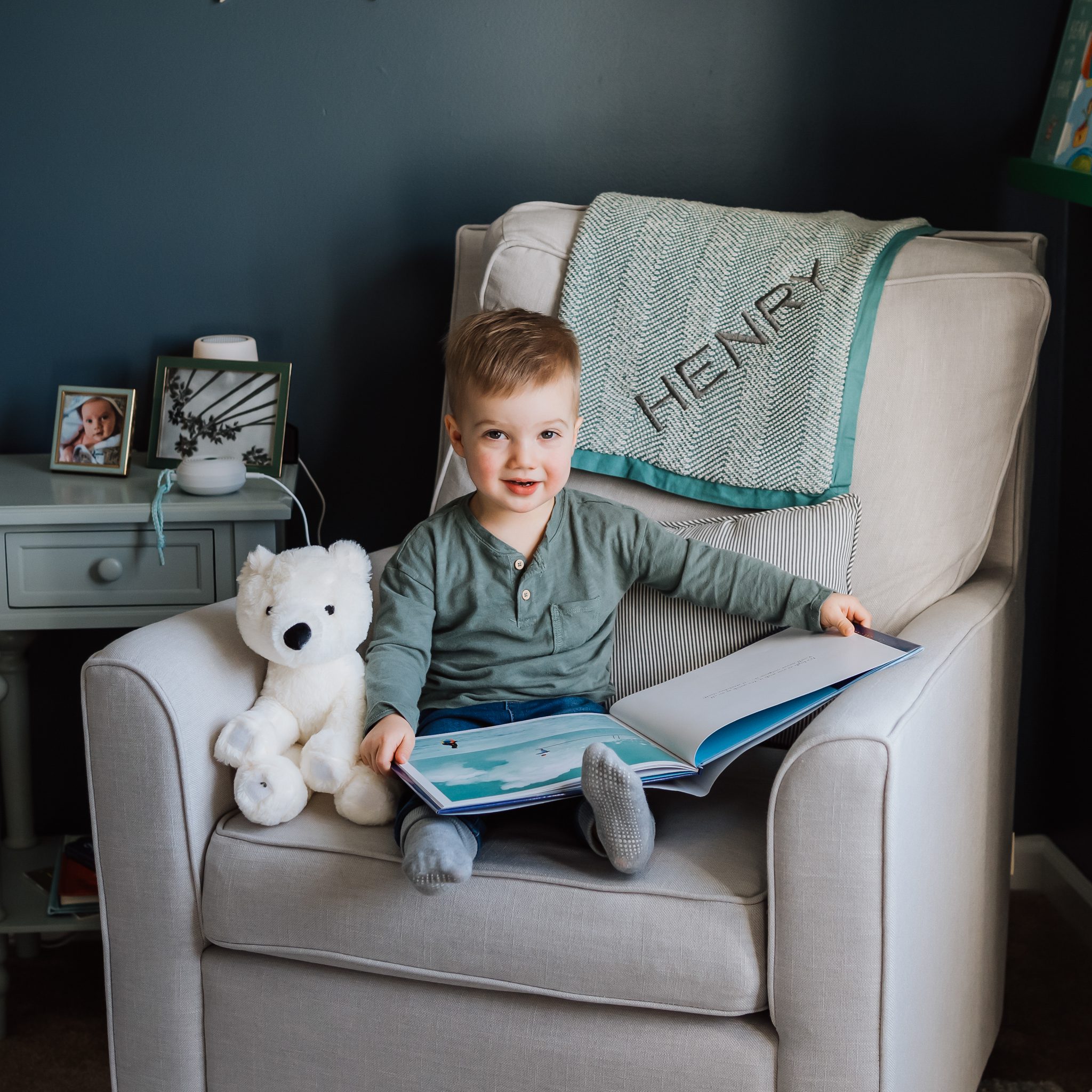 toddler boy sitting on a chair in his bedroom