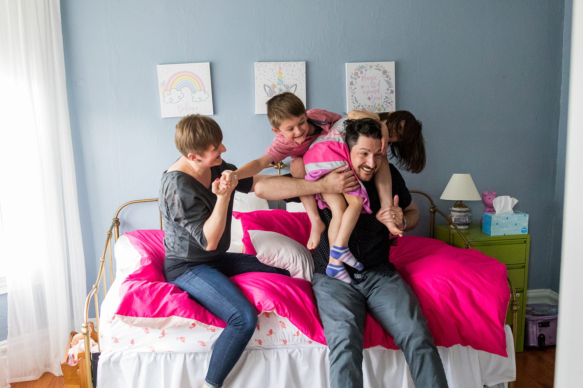 family playing together on a bed