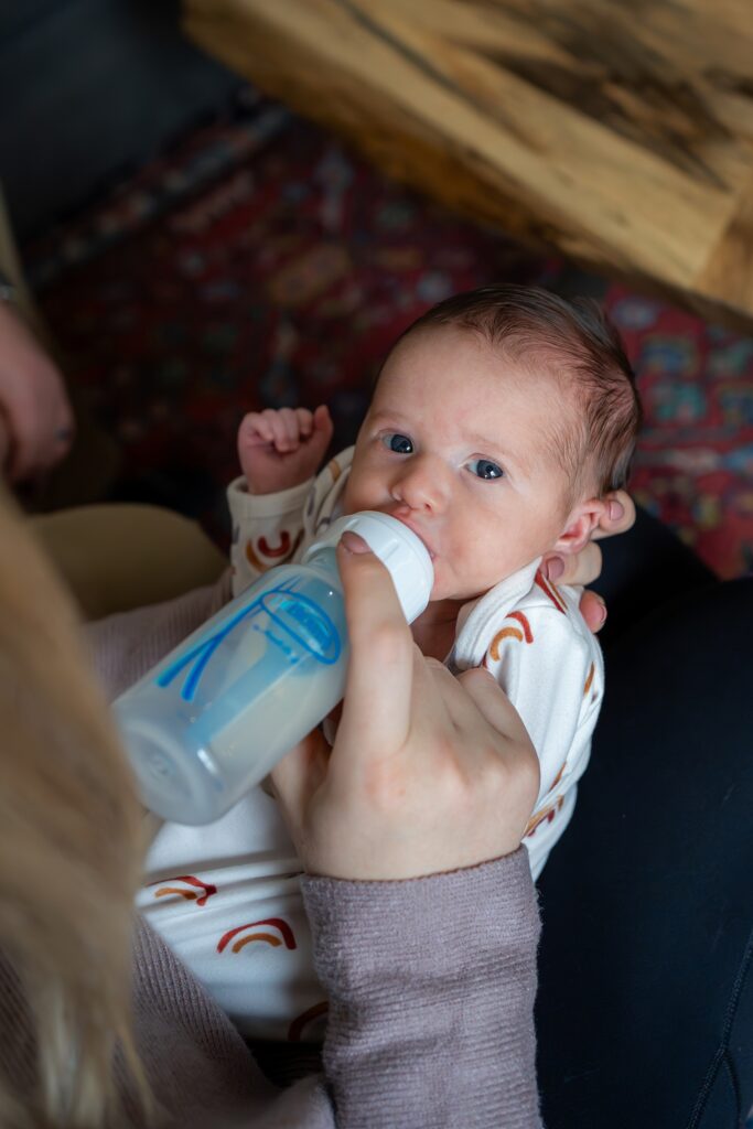 A woman feeding a baby with a bottle.