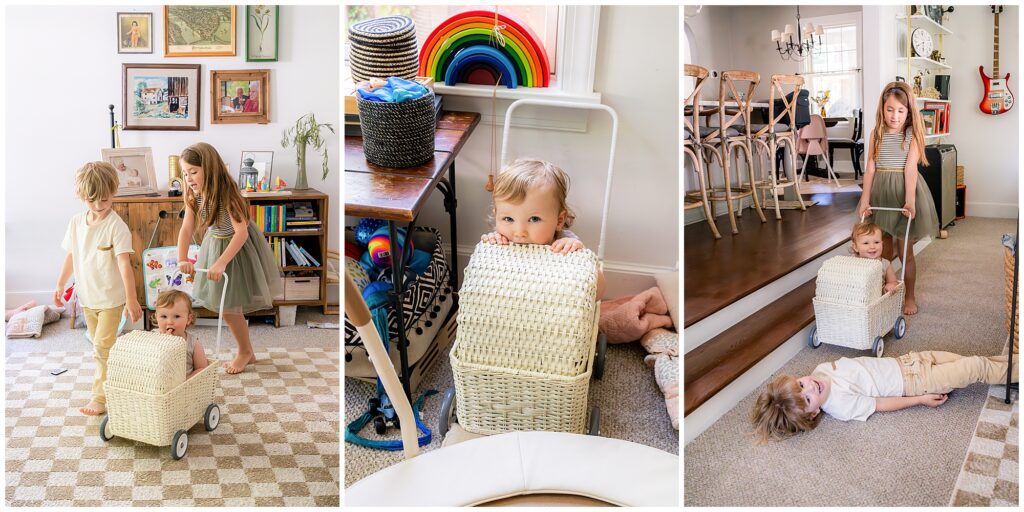 Children playing indoors; one child pushes a baby in a wicker cart while another adult-sized child lies on the floor. Walls are decorated with framed pictures and colorful toys.