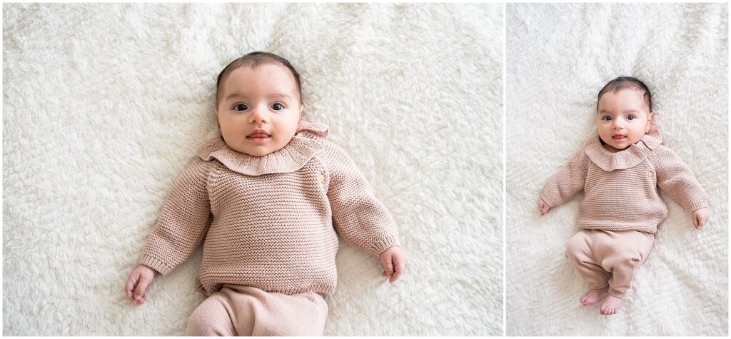 Baby lying on a soft, white textured blanket, wearing a knitted, beige outfit with a ruffled collar.
